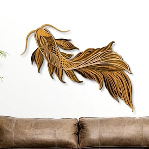 Puede incluir: Una escultura de pared de madera de un pez dorado con detalles intrincados. El pez está tallado con un diseño en capas y tiene una cola larga y fluida.