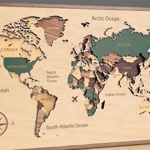 Könnte beinhalten: Weltkarte aus Holz mit Ländern in verschiedenen Farben, darunter Grün, Braun und Beige. Die Karte enthält die Namen der Ozeane und Länder. Eine Windrose befindet sich in der unteren linken Ecke. Flugzeuge sind ebenfalls abgebildet.