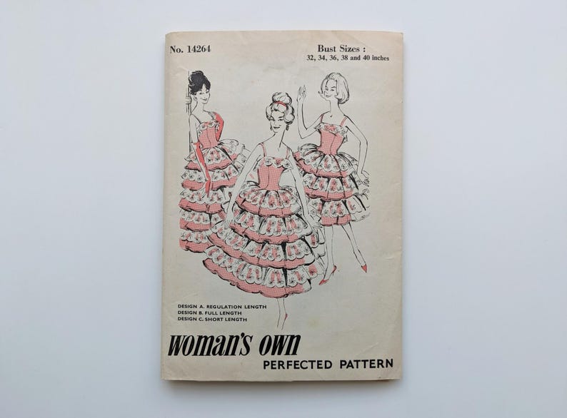 May include: Vintage sewing pattern titled "woman's own" with illustrations of three women in tiered dresses. The pattern includes bust sizes from 81 to 102 cm. The cover is aged with text that reads "No. 14264" and "PERFECTED PATTERN".