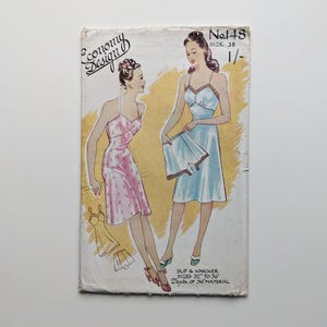 Puede incluir: Portada de patrón de costura vintage con ilustraciones de mujeres en enaguas. La portada muestra el texto "Economy Design" y "No. 148". El patrón es para tallas de 81 cm a 91 cm y requiere 1,8 metros de tela de 91 cm.