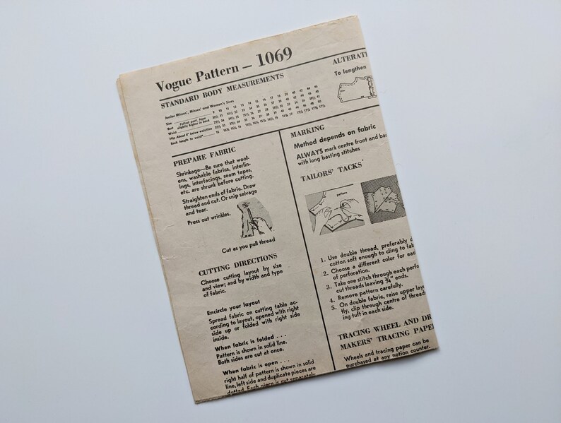 Puede incluir: Un patr&oacute;n de costura Vogue vintage, titulado "1069", con medidas corporales est&aacute;ndar e instrucciones. El papel blanquecino presenta texto e ilustraciones que detallan la preparaci&oacute;n de la tela, las instrucciones de corte y las t&eacute;cnicas de sastrer&iacute;a. El patr&oacute;n est&aacute; desgastado.