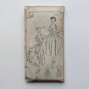 May include: Vintage dressmaking pattern with illustrations of women's dresses. The pattern is printed on aged paper with the word "Style" at the top. The number "34" is visible. The drawings depict various dress styles.