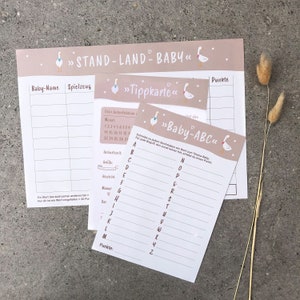 May include: A printable baby shower game with a pink and brown color scheme. The game is called "Stand Land Baby" and includes a "Baby-ABC" game card with a goose illustration. The game card has a list of letters from A to Z with lines for players to write down words related to the theme of "Baby".