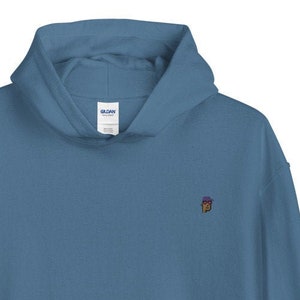 May include: A blue hooded sweatshirt with a small embroidered design on the front. The sweatshirt has a kangaroo pocket.