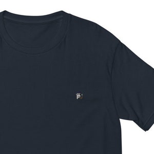 May include: A dark navy blue short-sleeved t-shirt with a small, embroidered design on the left chest.