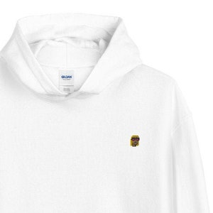 May include: White hooded sweatshirt with a small embroidered image of a person wearing sunglasses on the left chest.