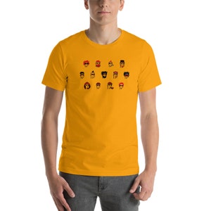 May include: A yellow short-sleeved t-shirt with a graphic print of 16 cartoon faces wearing various hats and sunglasses.