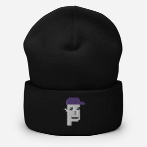 May include: Black beanie with a pixelated embroidered design of a person wearing a purple hat.