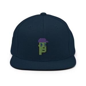 May include: A navy blue baseball cap with a green pixelated character wearing a purple hat embroidered on the front.