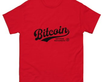 May include: Red t-shirt with a black vintage-style graphic that says "Bitcoin" with the text "Satoshi Nakamoto" underneath. The graphic also includes a black baseball-style arc and a Bitcoin symbol.