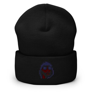 May include: Black beanie with a blue and red pixelated face embroidered on the front.