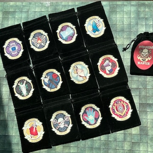 May include: Set of 14 black velvet drawstring bags with different colored embroidered designs. Each bag features a different Dungeons and Dragons class, including Paladin, Wizard, Ranger, Rogue, Bard, Cleric, Druid, Fighter, Monk, Sorcerer, Warlock, and more. The bags are perfect for storing dice, miniatures, and other gaming accessories.