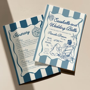 May include: Two blue and white striped wedding weekend itinerary cards. The cards feature the text "Seashells and Wedding Bells" and "Itinerary". The itinerary includes times and locations for events. The cards have a vintage, nautical theme.