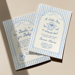 May include: Two rectangular baby shower invitation cards with light blue vertical stripes and a white arch frame. The cards feature a ghost illustration, bats, and spiderwebs. Text reads: A Little Boo is almost due! Books for Baby, Bonnie Adams.
