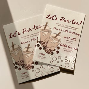 Op de afbeelding: Twee crèmekleurige uitnodigingen met de tekst "Let's Par-tea!" in een handschriftstijl. De uitnodigingen bevatten illustraties van bubble tea-drankjes en de tekst "Emma's 13th birthday". Extra tekst bevat de datum, tijd en locatie van het evenement.