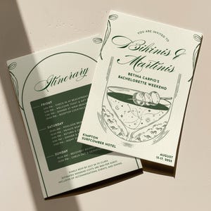 May include: Two ivory-colored invitation cards with green text and illustrations. The cards announce a bachelorette weekend with the theme "Bikinis & Martinis." One card lists the itinerary, and the other features a martini glass illustration.