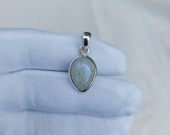 May include: A silver pendant with a teardrop-shaped moonstone.