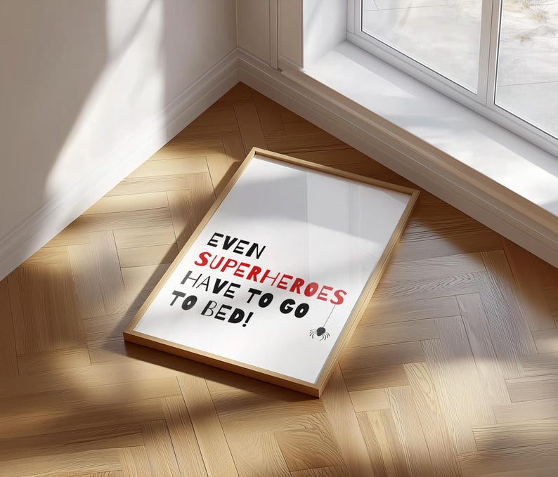 May include: A framed print with the text "EVEN SUPERHEROES HAVE TO GO TO BED!" in black and red lettering. A small black spider graphic is below the text.