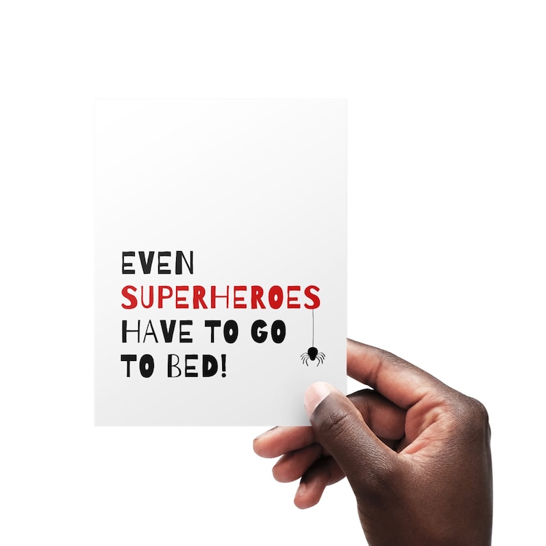 May include: White card with black text that reads "EVEN SUPERHEROES HAVE TO GO TO BED!" with a black spider hanging from the word "GO".