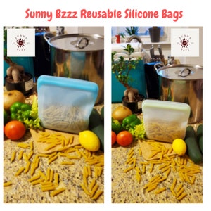 K&ouml;nnte beinhalten: Zwei transparente Silikonbeutel gef&uuml;llt mit Pasta auf einer Arbeitsplatte. Die Beutel sind mit "Sunny Bzzz Reusable Silicone Bags" beschriftet.