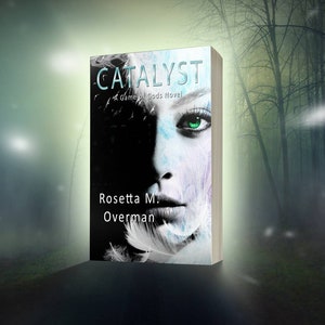 May include: A book cover for "Catalyst: A Game of Gods Novel" by Rosetta M. Overman. The cover features a woman's face with striking green eyes, partially obscured by shadow. The title is in teal, with white text on the spine.