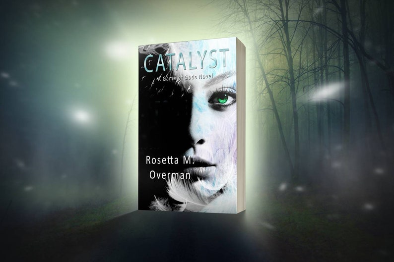 May include: A book cover for "Catalyst: A Game of Gods Novel" by Rosetta M. Overman. The cover features a woman's face with striking green eyes, partially obscured by shadow. The title is in teal, with white text on the spine.