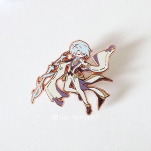 May include: A gold-toned enamel pin featuring a cartoon character with white hair, wearing a white and purple outfit, and holding a white and gold staff. The character is in a dynamic pose with their arms outstretched. The pin has a white background and the text "@nst_storypict" is visible in the bottom right corner.