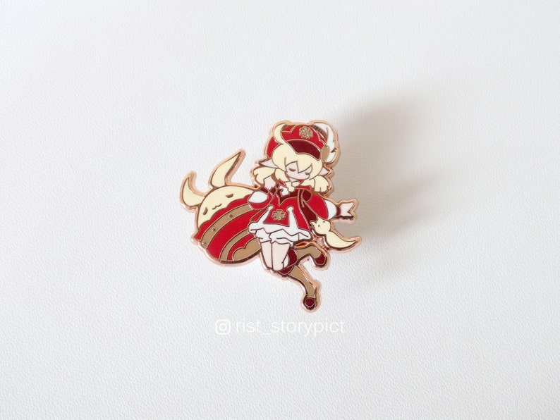 May include: A gold-tone enamel pin featuring a cartoon character with blonde hair wearing a red and white outfit and a crown. The character is riding a white and gold animal with a red and gold body.