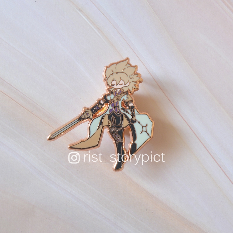 May include: Gold-colored enamel pin featuring a cartoon character with blonde hair, wearing a white and purple outfit, holding a sword and standing on a light blue and white background. The pin has the text "@rist_storypict" at the bottom.
