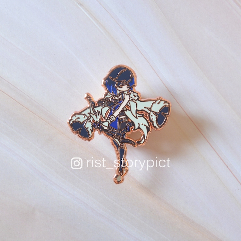 May include: A gold-colored enamel pin featuring a cartoon character with blue hair, a blue and white outfit, and a bow and arrow. The character is wearing a white cloak with a fluffy trim. The pin is on a white background.  @rist_storypict