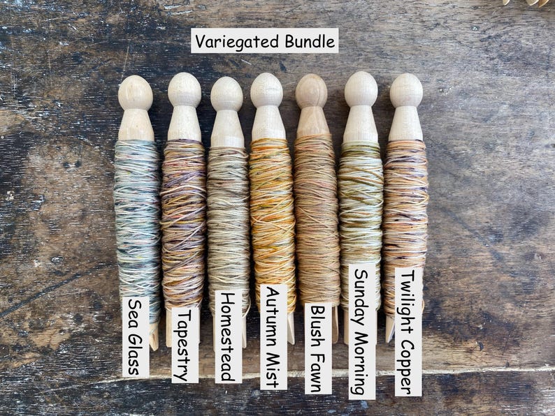 Pu&ograve; includere: Un Variegated Bundle di sette rocchetti di legno avvolti nel filo. Le etichette riportano Sea Glass, Tapestry, Homestead, Autumn Mist, Blush Fawn, Sunday Morning e Twilight Copper. Ogni rocchetto presenta una base e una cima in legno.