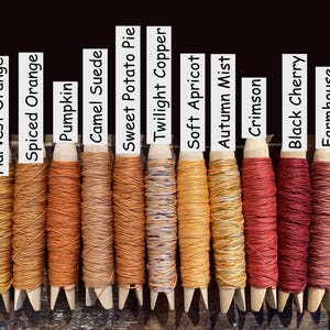 Pu&ograve; includere: Tredici mollette da bucato in legno avvolte con filo colorato, etichettate Cinnamon, Harvest Orange, Spiced Orange, Pumpkin, Camel Suede, Sweet Potato Pie, Twilight Copper, Soft Apricot, Autumn Mist, Crimson, Black Cherry, Farmhouse e Scarlet.