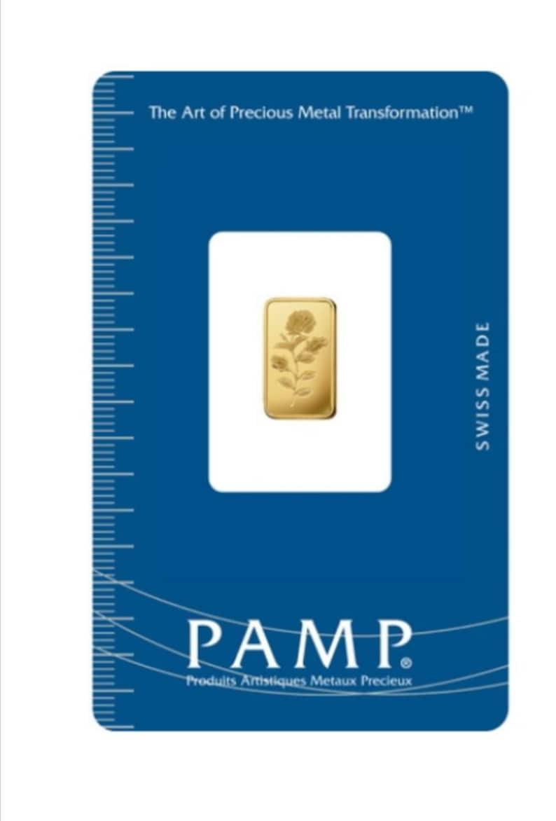 May include: A gold bar with a rose design, packaged in a blue card with the text "The Art of Precious Metal Transformation" and "PAMP Produits Artistiques Metaux Precieux" and "SWISS MADE".