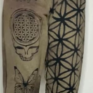 May include: Brown sweatpants with black tie-dye designs. The designs include a sunflower, a butterfly, a tree, a skull, and a geometric pattern.