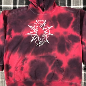 May include: Red and black tie-dye hoodie with a white graphic of a goat in a star.