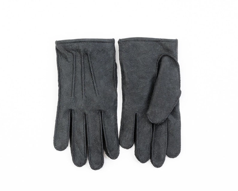 May include: A pair of black leather gloves with a stitched design.