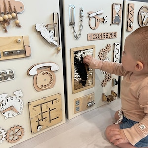 May include: Wooden activity boards featuring interactive elements like latches, gears, a clock, and a sequin panel. Designed for early childhood development and sensory exploration, these boards are a learning tool.