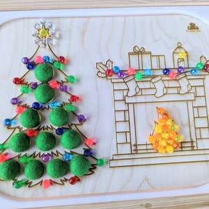 Puede incluir: Un tablero de madera con temática navideña con un diseño de árbol y chimenea. El árbol tiene adornos de fieltro verde y luces de cuentas de colores. La chimenea tiene calcetines y una llama de cuentas. Una estrella corona el árbol.
