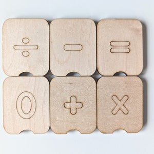 May include: Six wooden tiles with different mathematical symbols: divide, minus, equals, zero, plus, and multiply.