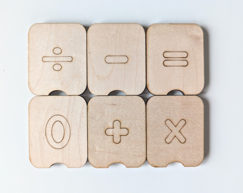 May include: Six wooden tiles with different mathematical symbols: divide, minus, equals, zero, plus, and multiply.