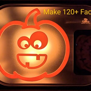 Pode incluir: Uma abóbora laranja brilhante com um rosto amigável, iluminada por dentro. A abóbora é contornada em vermelho e tem dois olhos grandes, um sorriso largo e dois dentes. O texto "Make 120+ Faces!" é exibido acima da abóbora.
