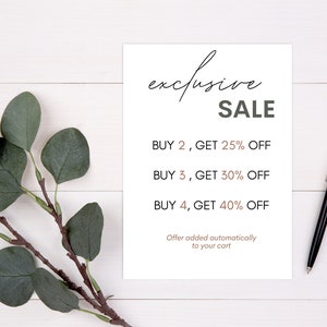 May include: A white sign with black text that reads "exclusive SALE" and lists discounts for buying multiple items. The text reads "BUY 2, GET 25% OFF", "BUY 3, GET 30% OFF", and "BUY 4, GET 40% OFF". The sign also includes the text "Offer added automatically to your cart".