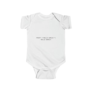 May include: White baby bodysuit with short sleeves. The text "PRINT ("HELLO WORLD!")" and "HELLO WORLD!" is printed in black. The bodysuit is made of a soft, comfortable material.