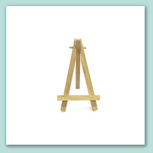 May include: A small wooden easel, perfect for displaying small artwork or photos. The easel is made of natural wood and has a simple, classic design.