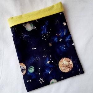 May include: A small, dark blue fabric pouch with a yellow top. The pouch has a space-themed print with planets, stars, and constellations.