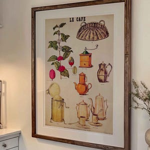May include: A kitchen with white cabinets, a stainless steel cooker, and a framed print of a coffee plant with the text "Le Cafe".