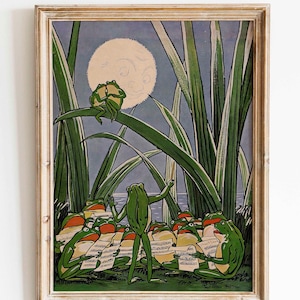 Peut inclure: Une impression d'art encadrée représentant une scène fantaisiste de grenouilles dans un marais au clair de lune. L'œuvre représente plusieurs grenouilles vertes, certaines tenant des partitions, avec de grands roseaux verts et une grande lune ronde en arrière-plan.