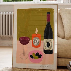 Könnte beinhalten: Ein rechteckiger Wandkunstdruck mit einer stilisierten Illustration eines Rotweinglases, einer orangefarbenen Kerze mit dem Text GLOW, einer dunklen Weinflasche und einer kleinen rosa Schale mit grünen und schwarzen Oliven, mit dem handschriftlichen Text one more? unten.