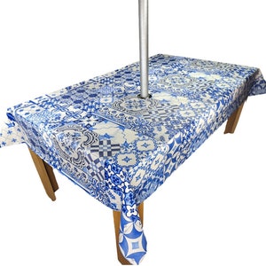 May include: A white tablecloth with a blue and white tile pattern. The tablecloth has a hole in the centre for an umbrella pole.