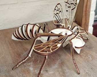 May include: A wooden model of a wasp with intricate details. The model is made of laser-cut wood and has a natural wood finish.